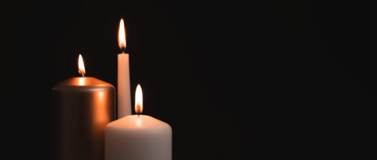 Three candles lit at a memorial for a wrongful death.